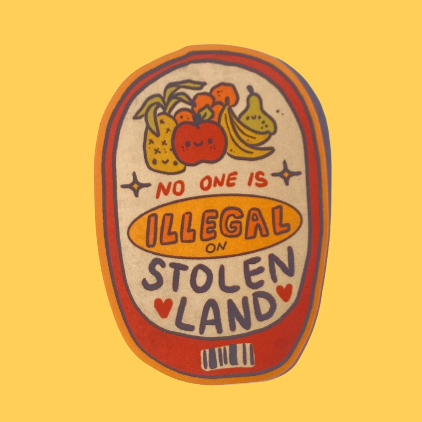 Sticker with fruit illustration and text 'No one is illegal on stolen land' on a textured white background